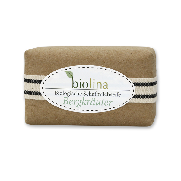 Biolina Schafmilchseife 100g verpackt mit braunem Papier und Dekoband gestreift, Bergkräuter 